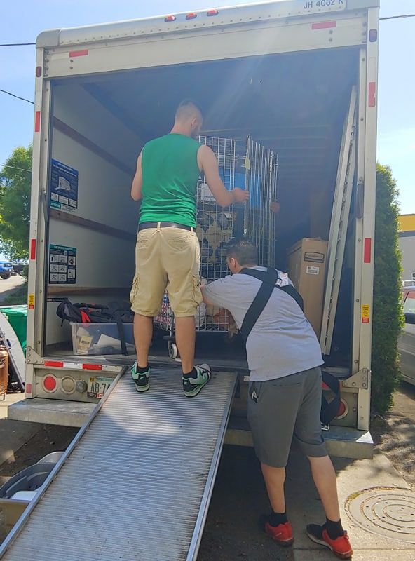 Ryan and James loading a rack and cage into a box truck